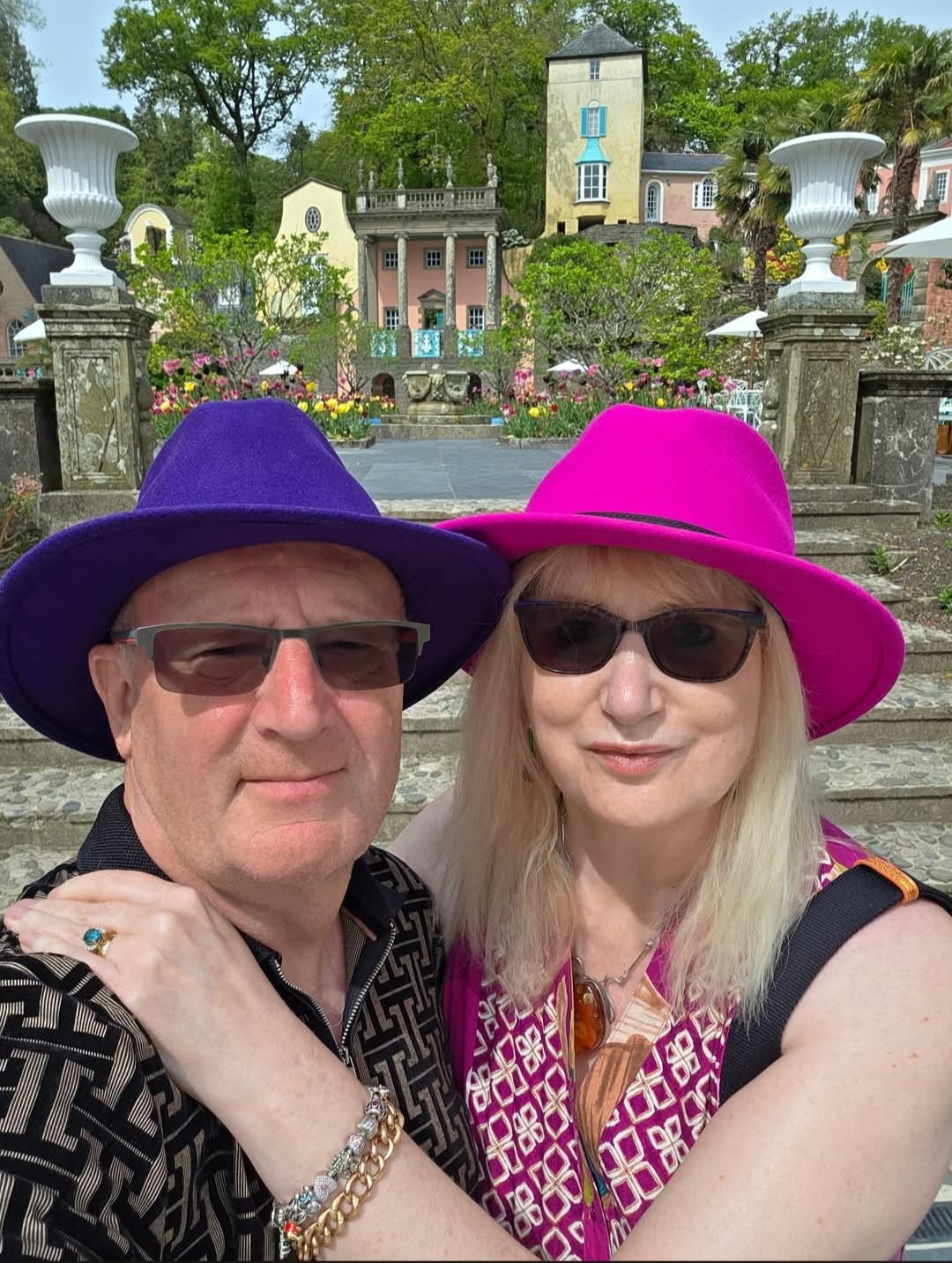 A man and woman wearing hats and smiling into the camera
