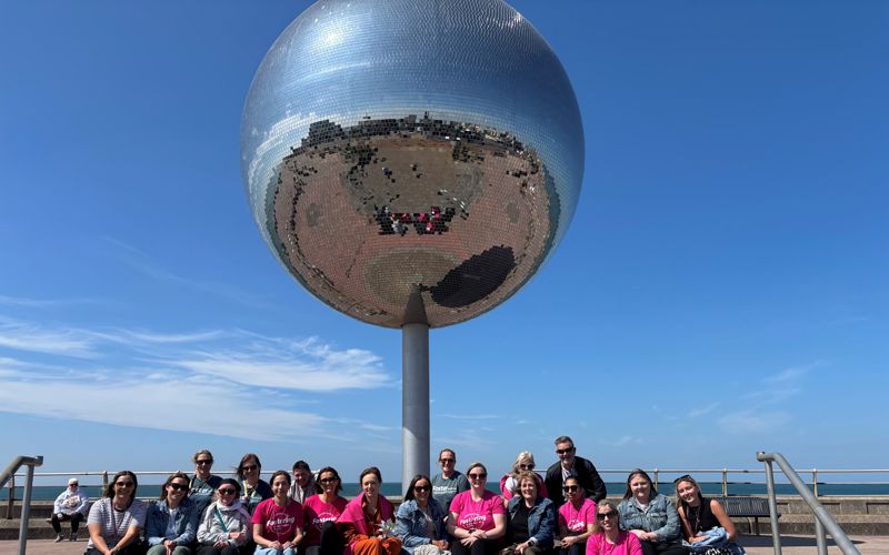Foster carers and their children with the fostering team in front of the Mirror Ball