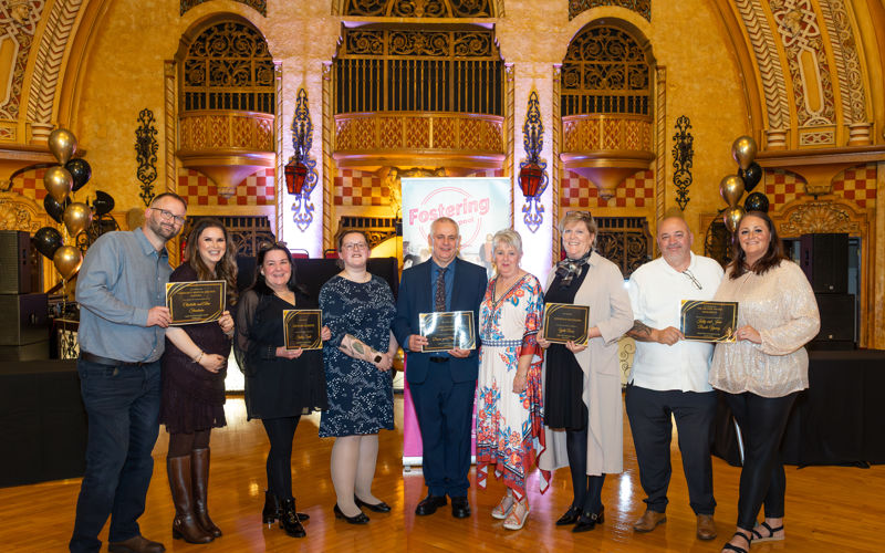 Foster carer award winners stood in a line smiling
